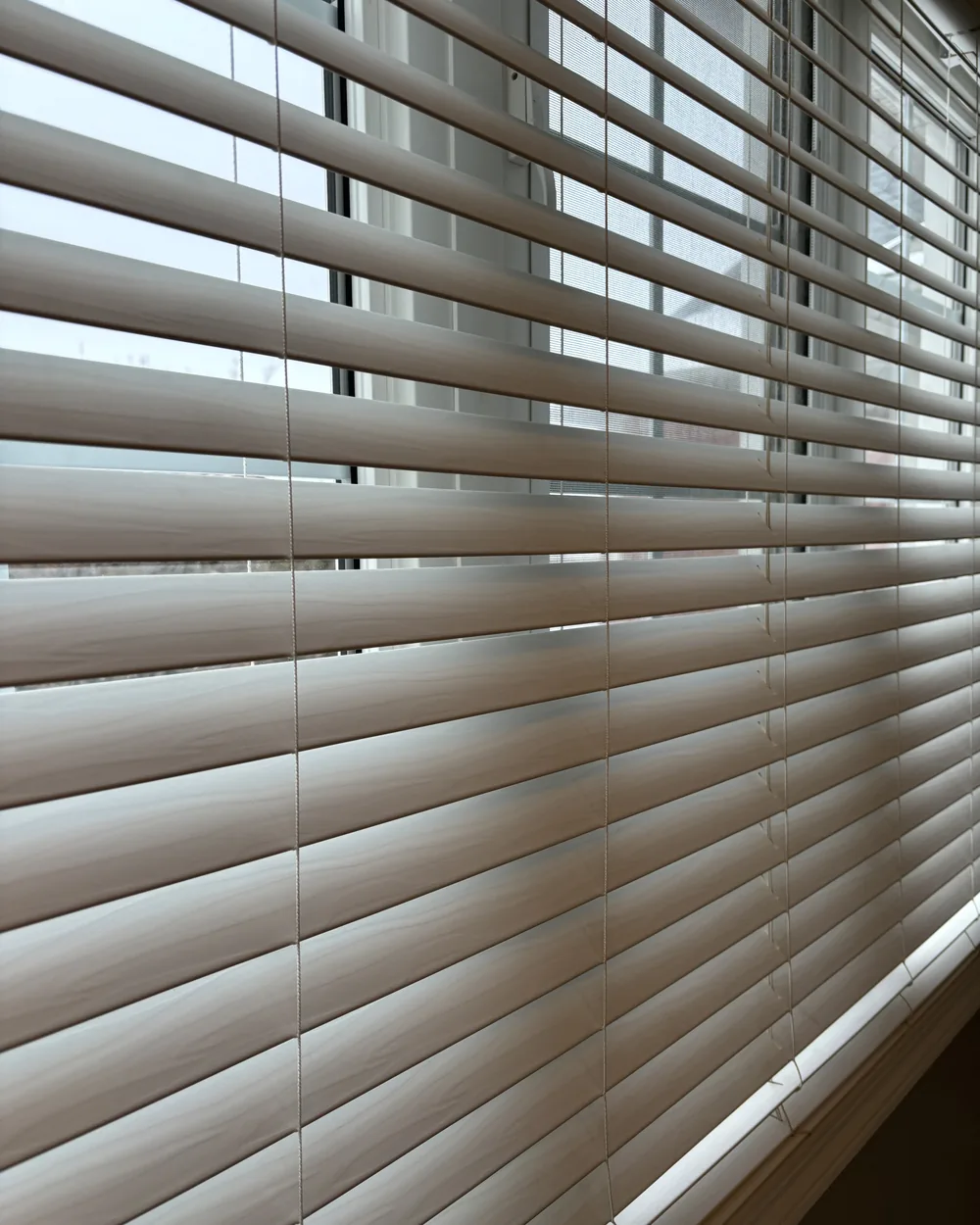 Clean wood look window blinds with daylight behind them