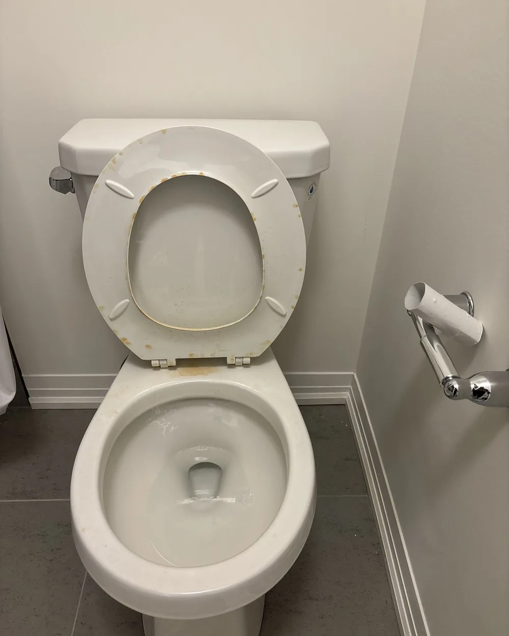 A toilet with staining on the seat and rim