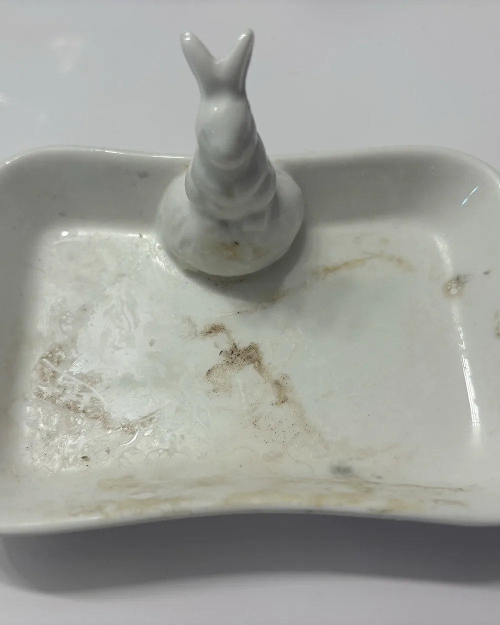 A ceramic dish with brown staining across the base