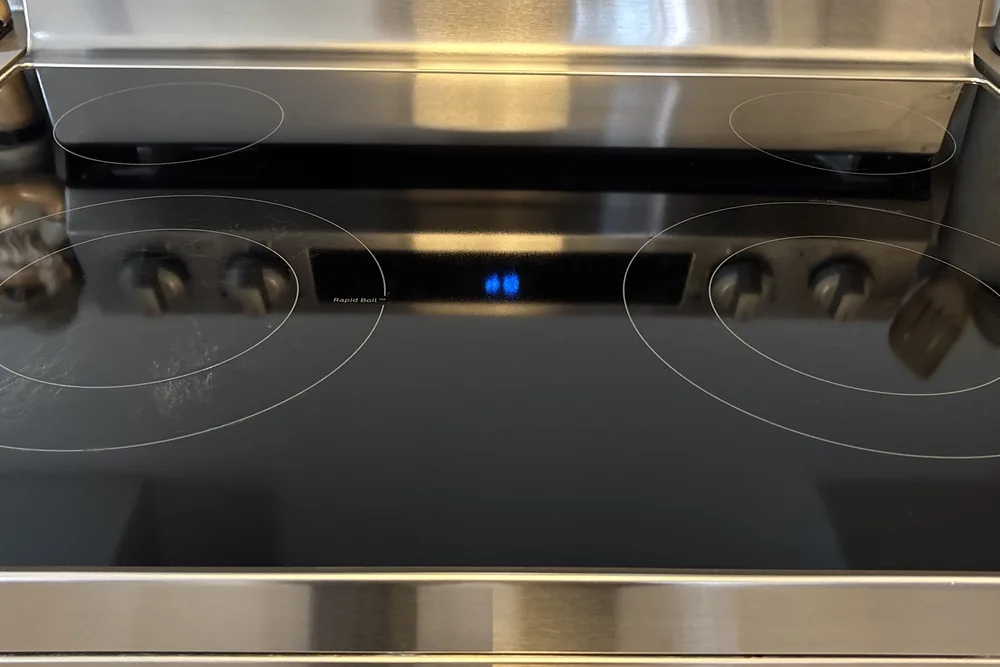 A clean glass cooktop and stainless steel range